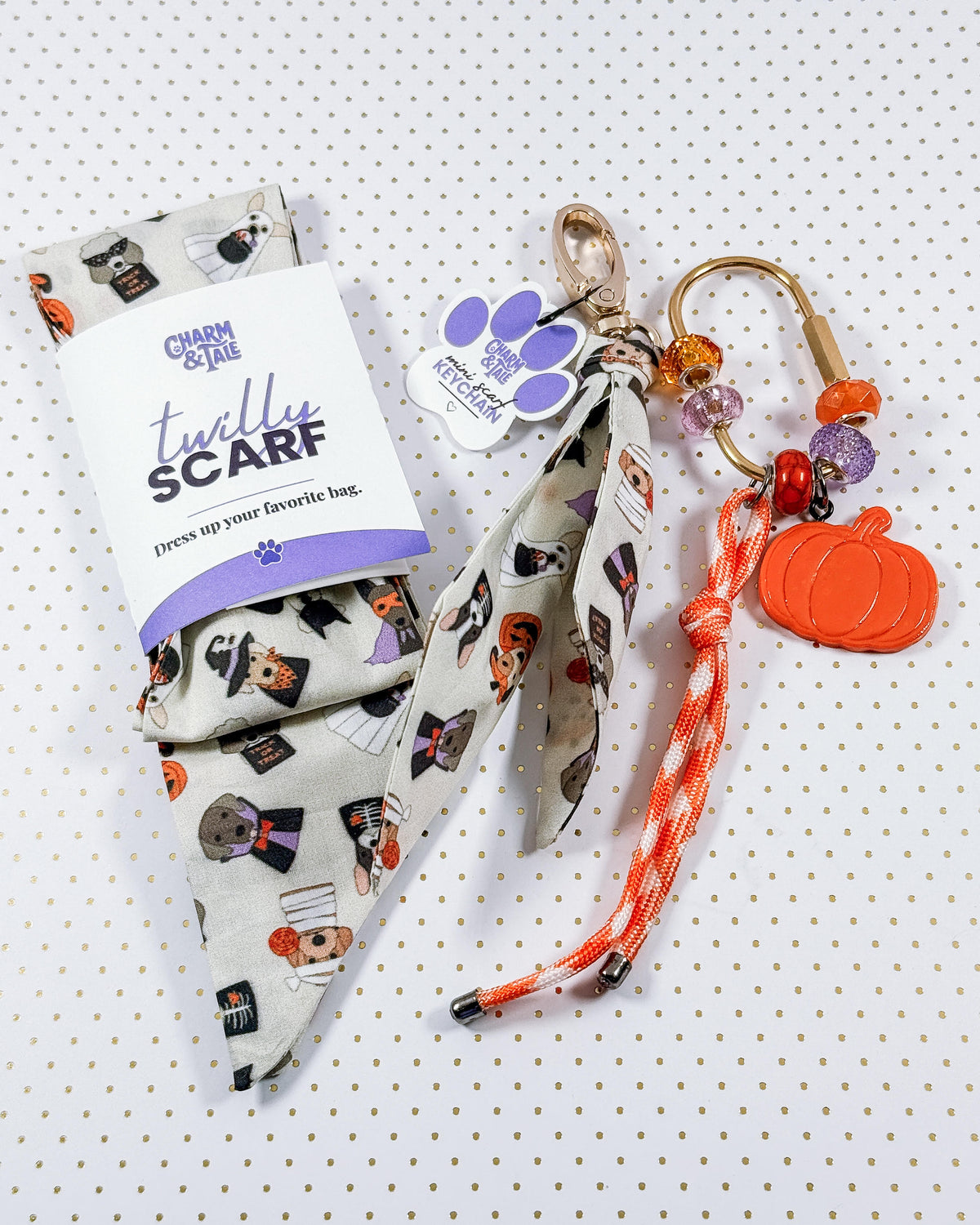 scarf, keychain, and bag charm featuring dogs dressed up for trick-or-treating
