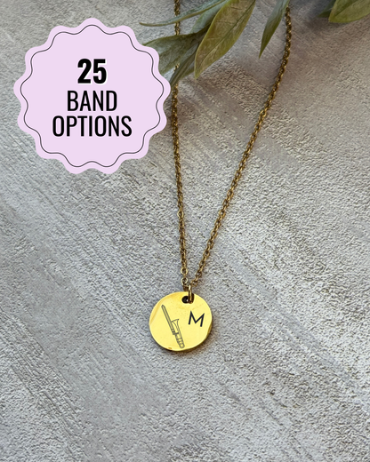 Gold necklace with a round pendant on a textured surface with a '25 Band Options' label.