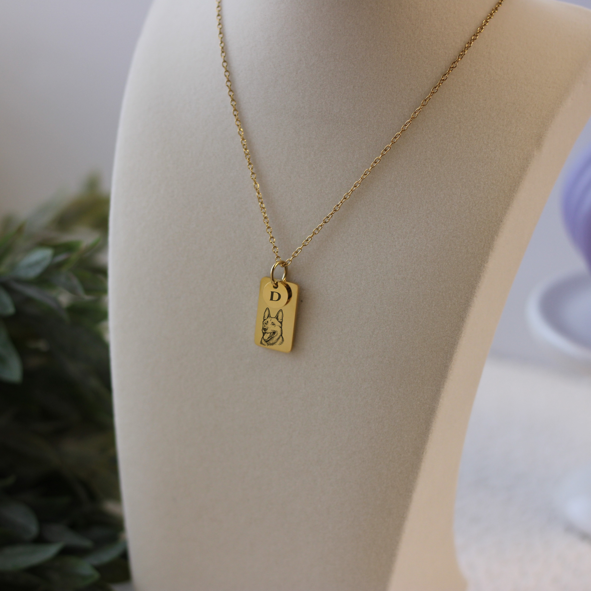 Gold necklace with a pendant on a mannequin bust