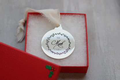 Decorative ornament with 'The Meek Family' engraving in a red box on a gray background