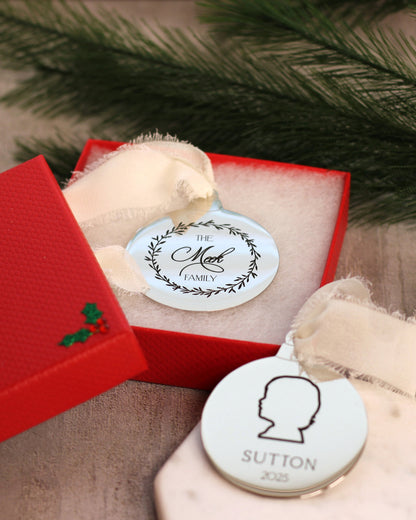 Personalized ornament with engraved name and family crest in a red box.