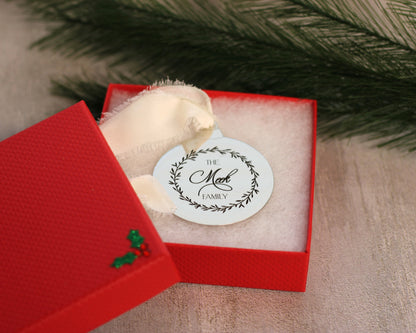 Decorative ornament with a family name tag in a red box against a natural background