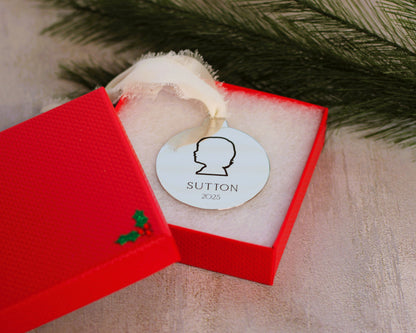 Decorative ornament with 'Sutton 2023' text in a red box with a Christmas tree design.