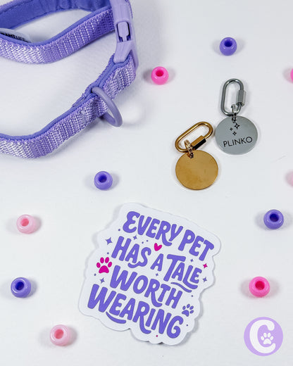 Pet collar with tags and a sticker on a light background