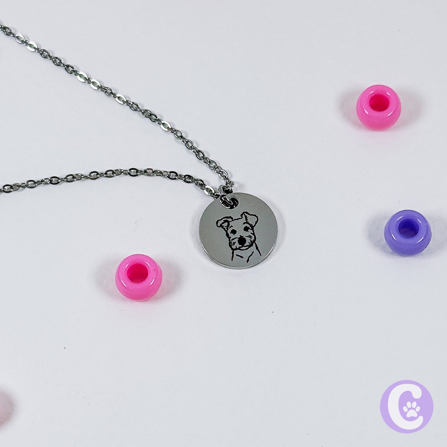 Necklace with a round pendant featuring a dog illustration on a white background with colorful beads.