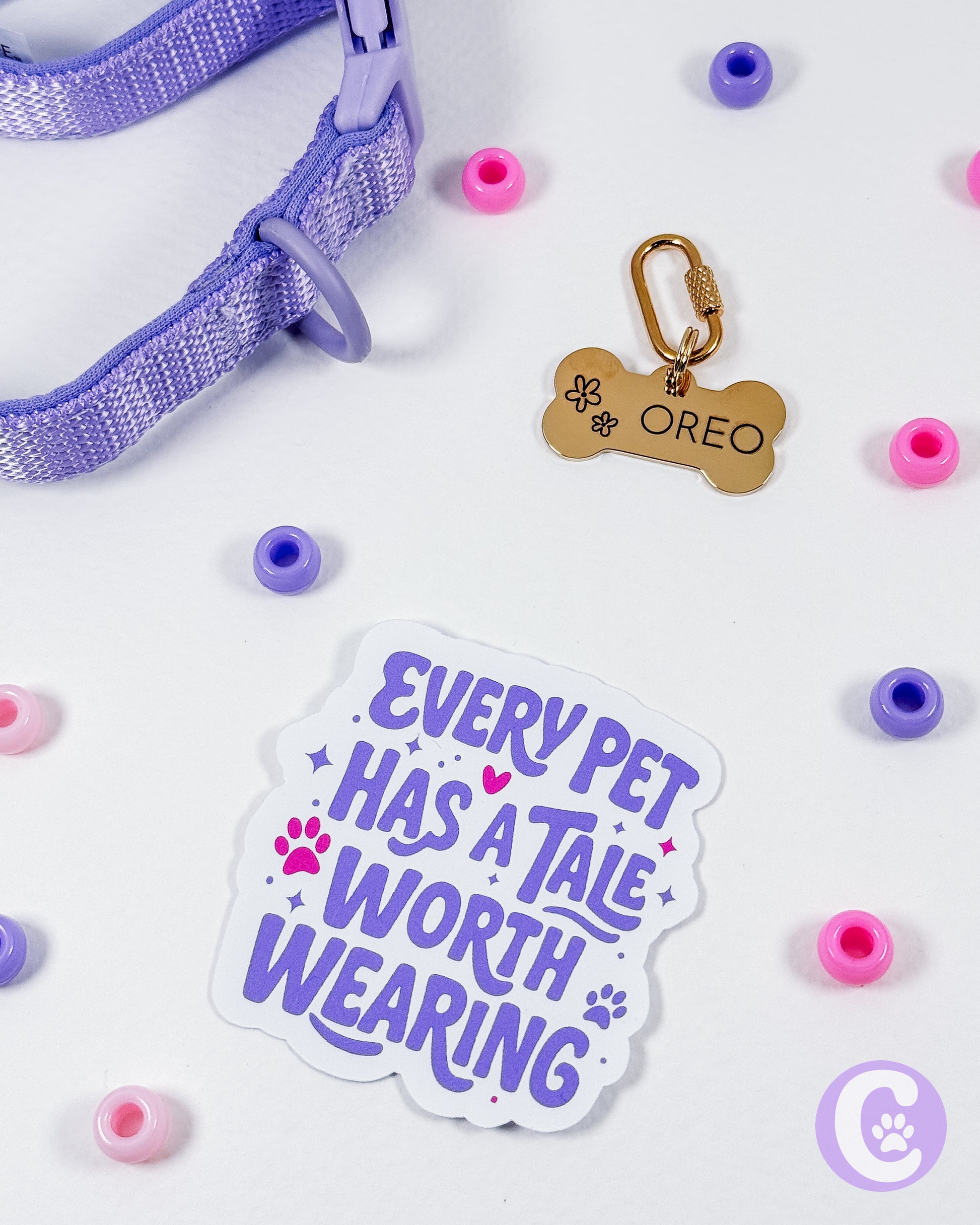 Pet collar with tag, sticker, and colorful beads on a light background