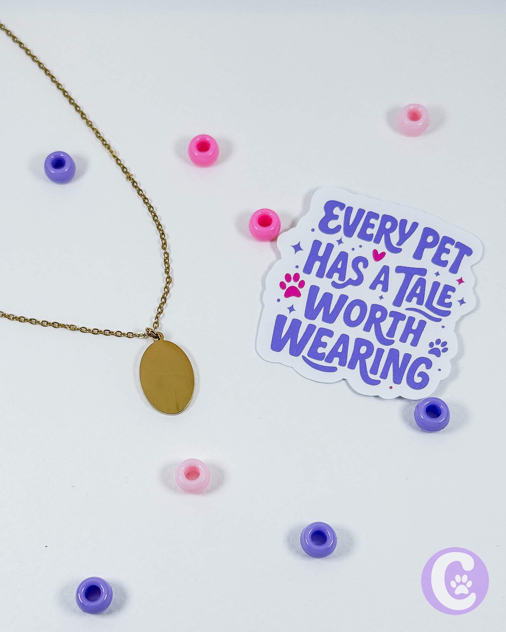 Sticker with 'Every pet has a tale worth wearing' text on a white background with beads and a necklace.
