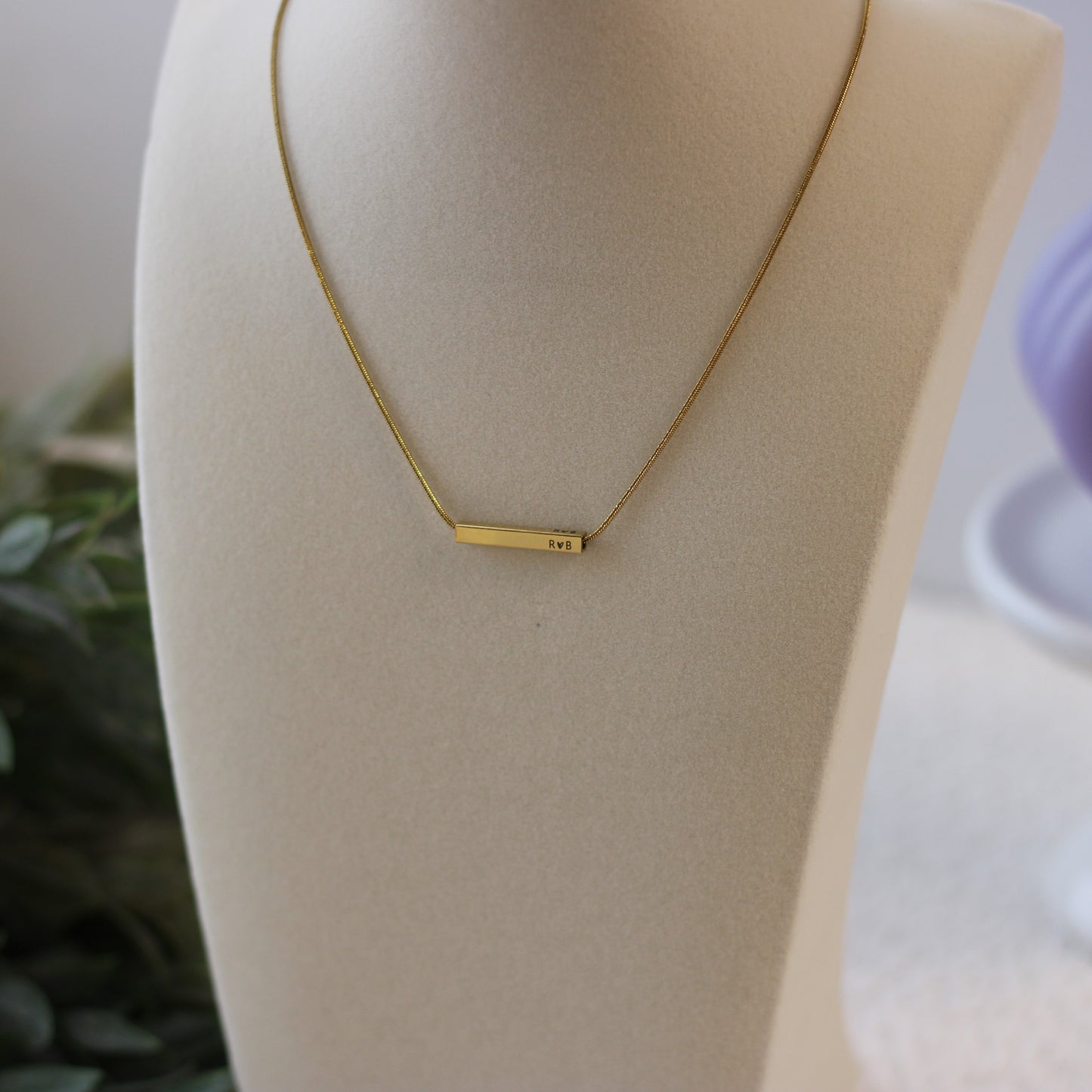 Gold necklace on a mannequin bust with a blurred background