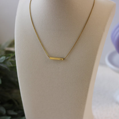 Gold necklace on a mannequin bust with a blurred background