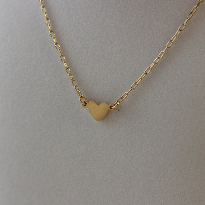 Gold heart-shaped pendant necklace on a plain background