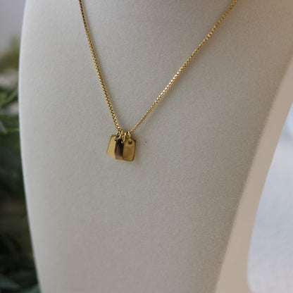 Gold necklace with a pendant on a mannequin bust.