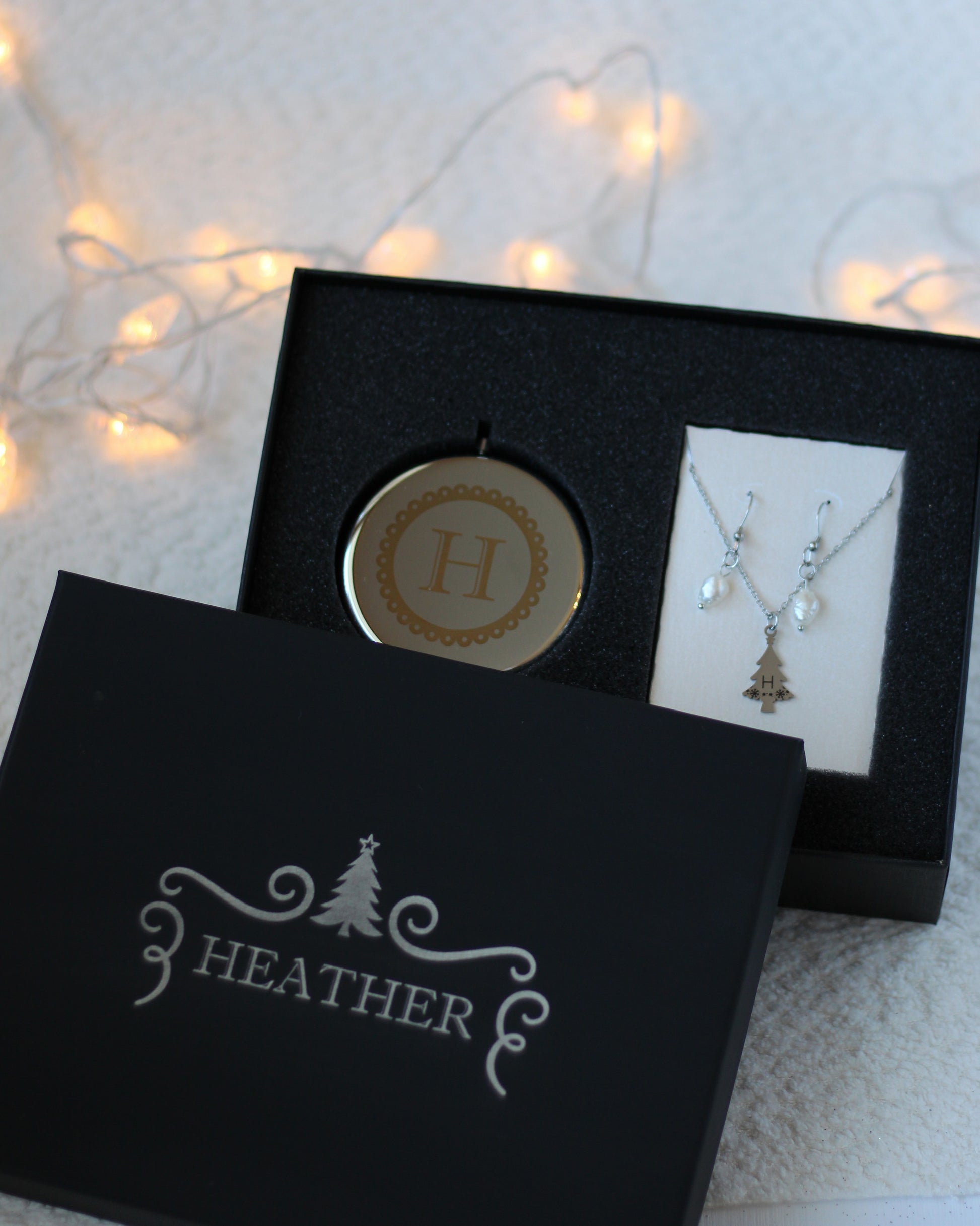Jewelry set with pendant and necklace in a black box labeled 'Heather' on a soft background.