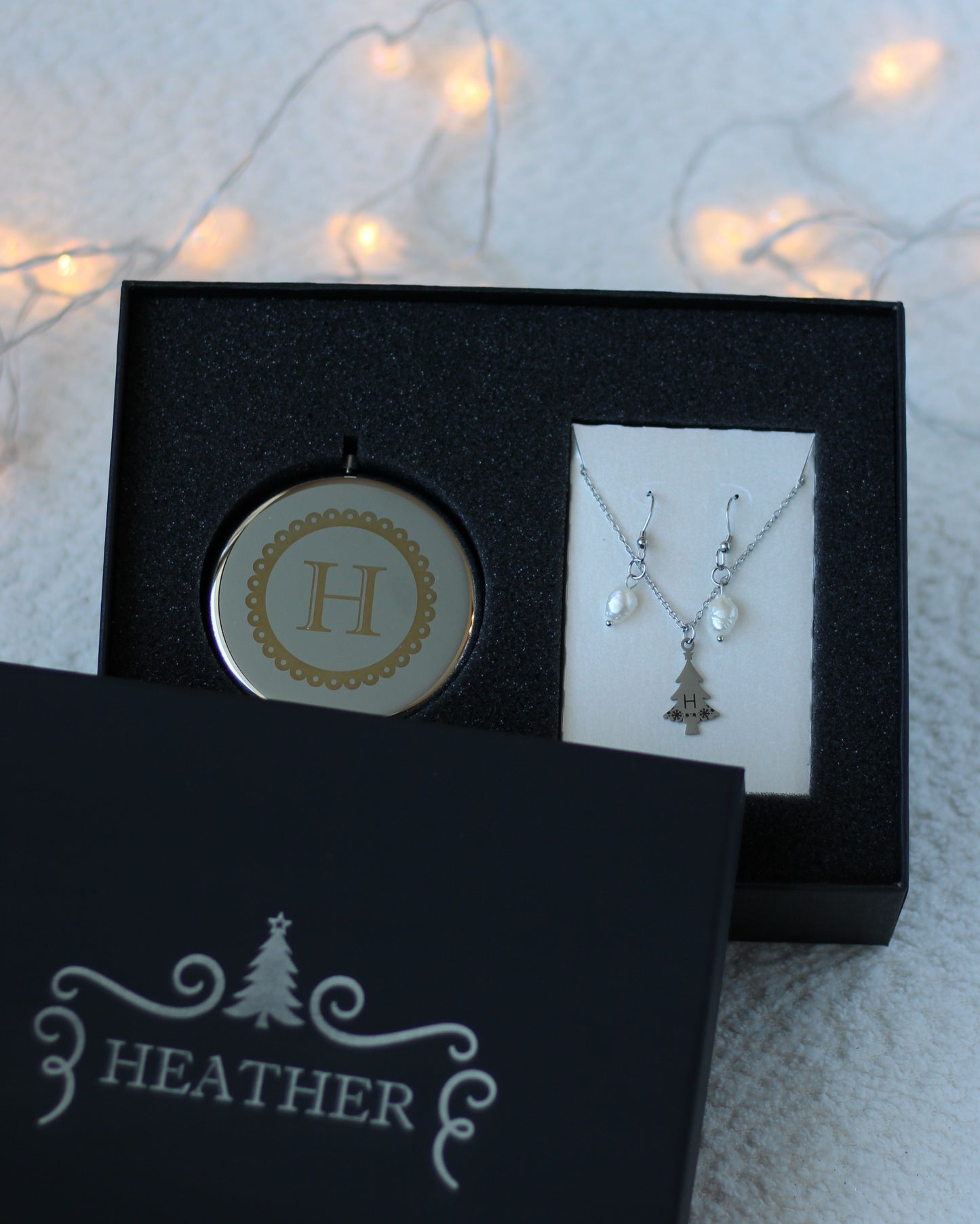 Jewelry set with pendant and necklace in a black box labeled 'Heather' on a light background.