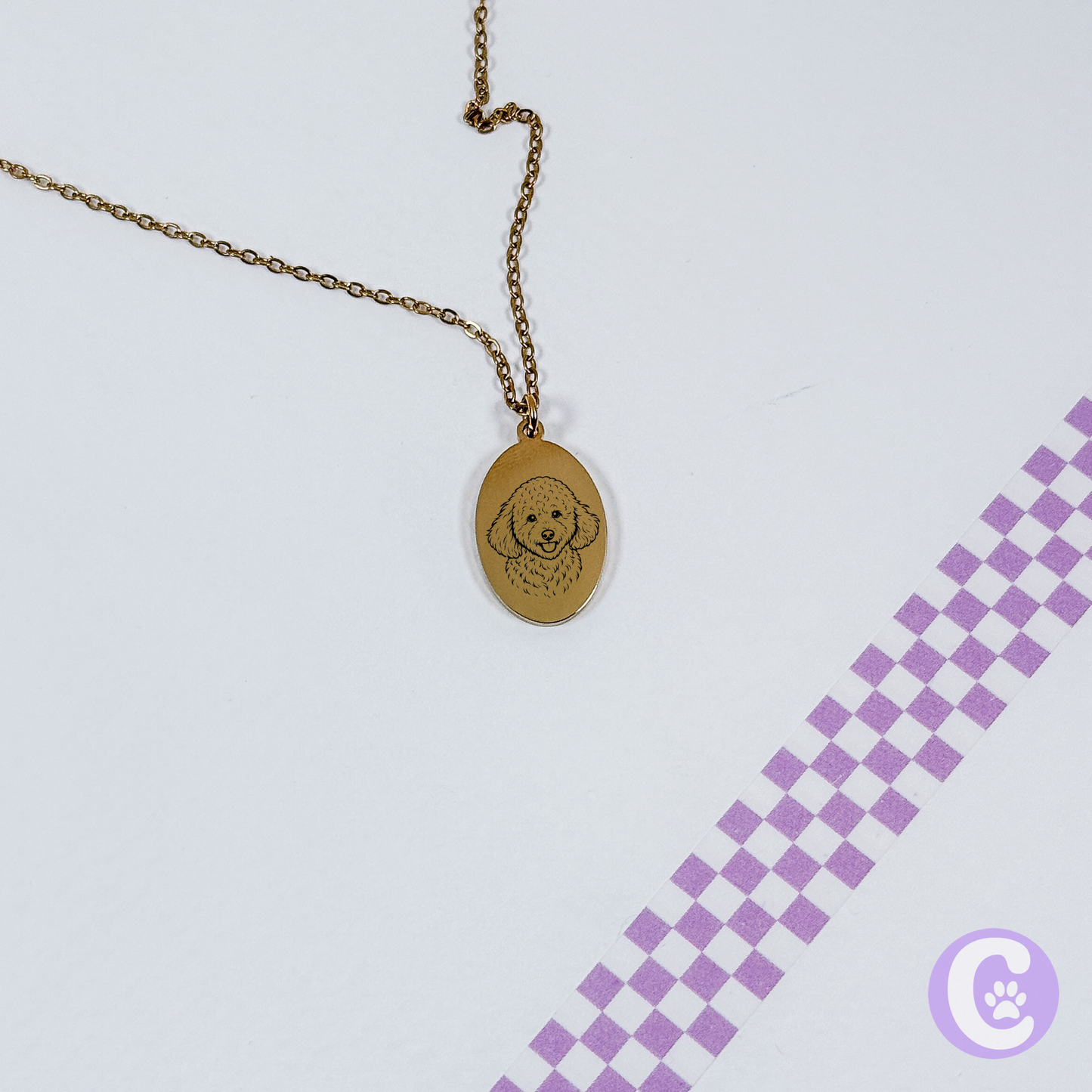 Gold necklace with pet line art pendant on a light purple background