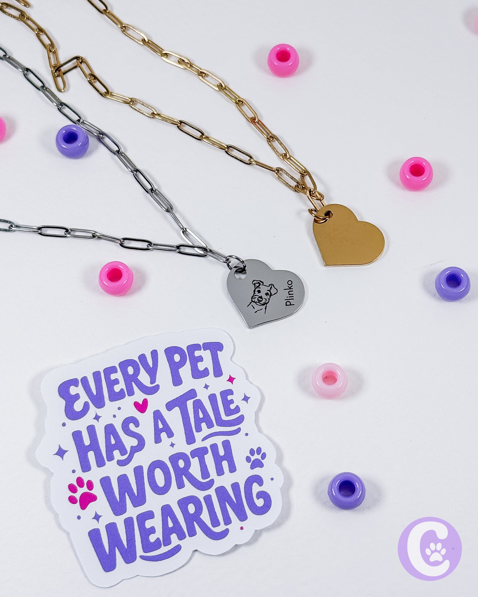Necklaces with heart-shaped pendants and a sticker with text on a light background