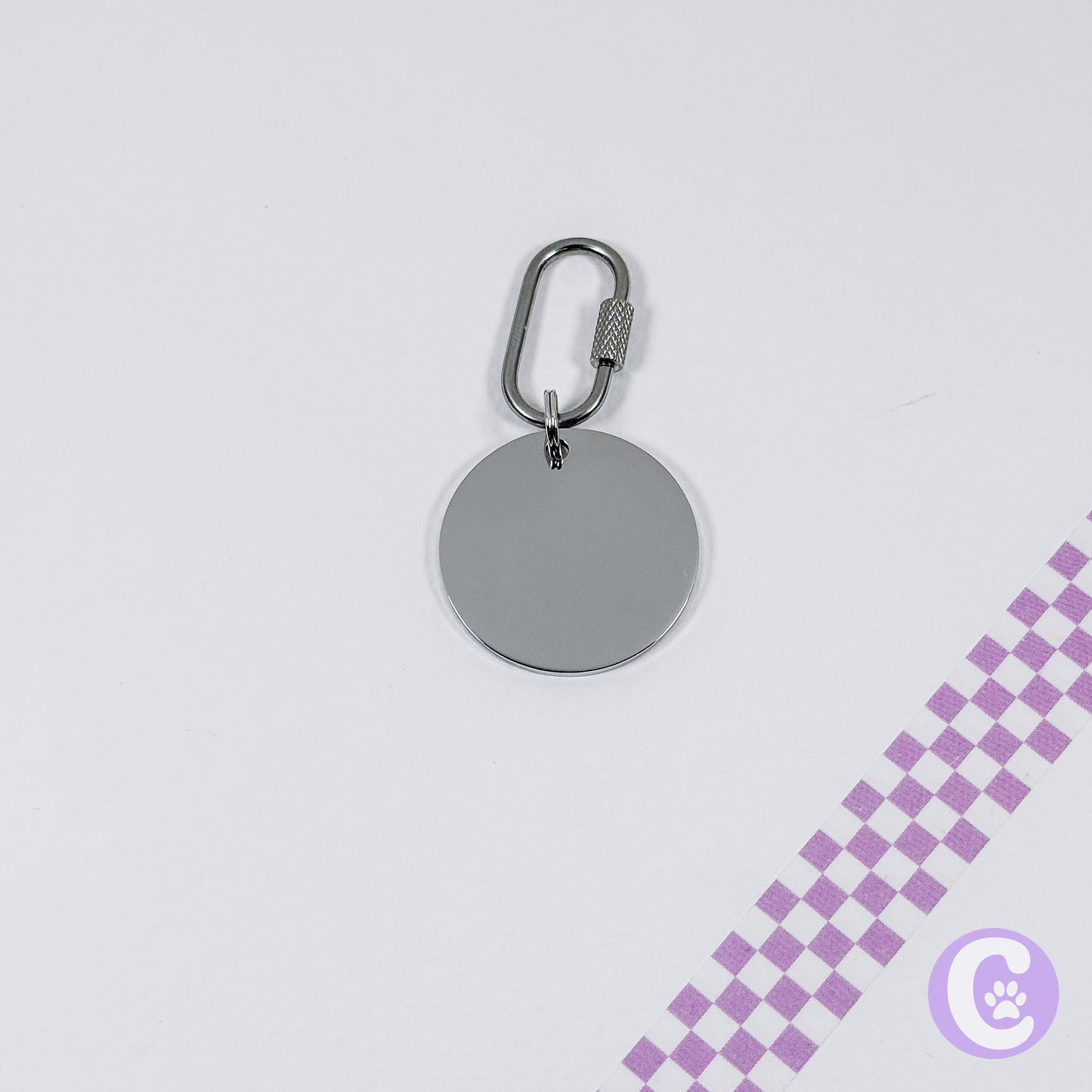 Silver keychain with a round tag on a light gray background