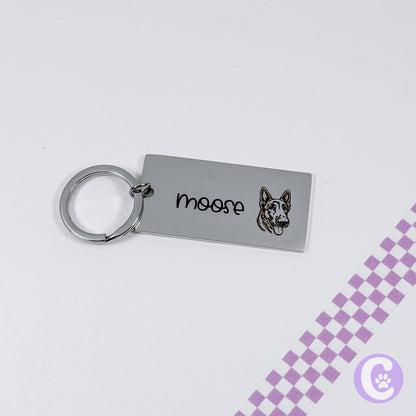 Metal keychain with 'moose' and a dog illustration on a light gray background