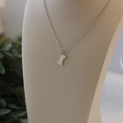 Silver necklace with a small pendant on a mannequin bust.